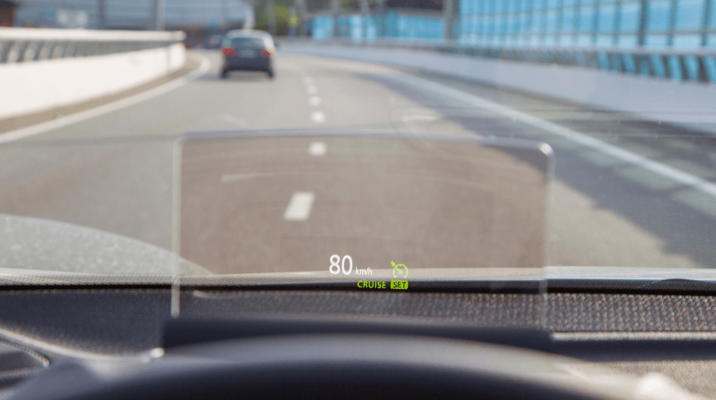 Heads-Up Display (HUD) projecting vehicle speed and adaptive cruise control onto a luxury windshield while driving