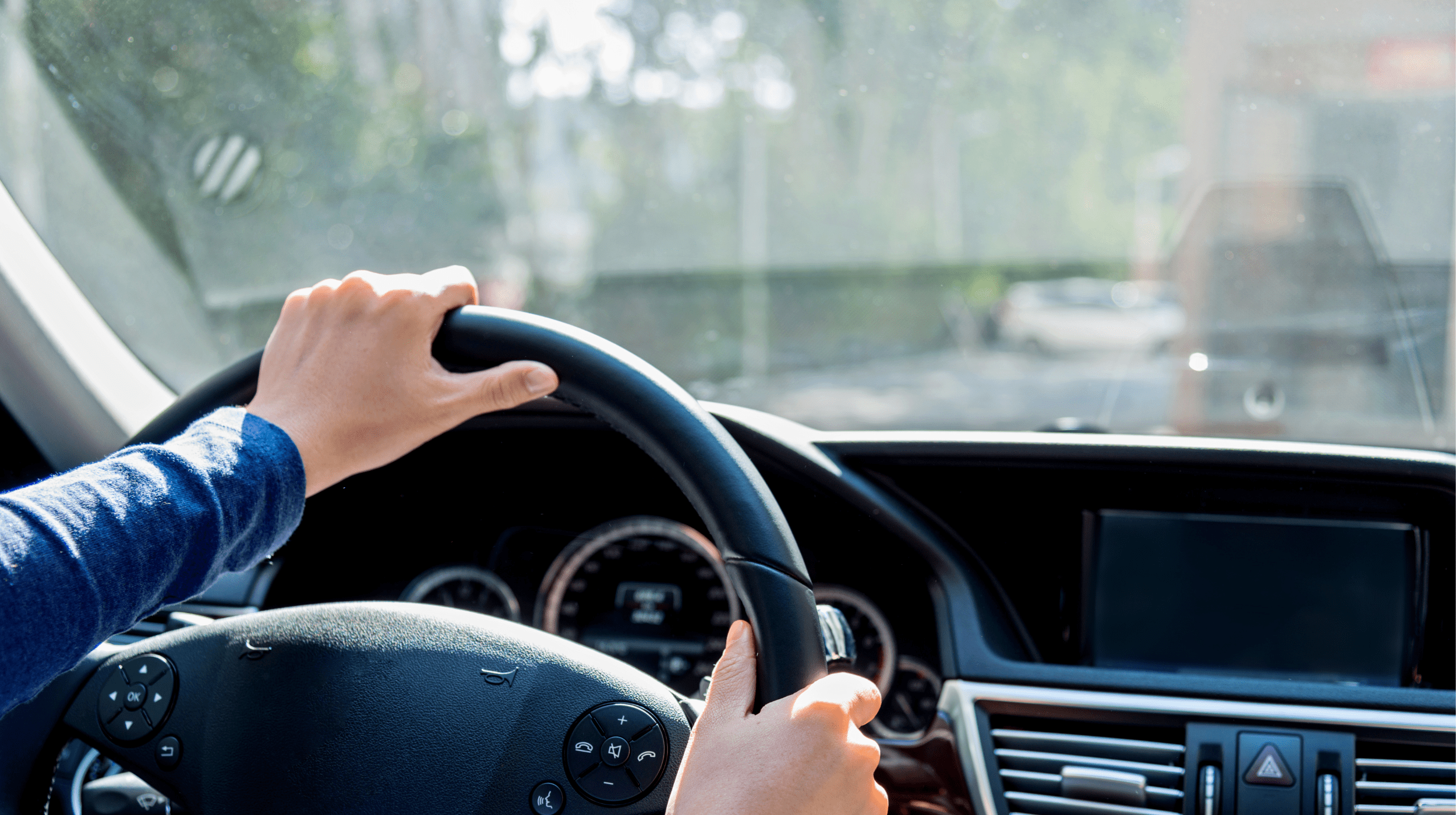Driver behind the wheel of a vehicle with an unobstructed windshield meeting state safety laws